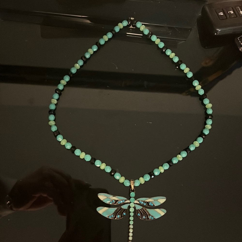 An amazing handmade necklace with a beautiful dragonfly in the middle.